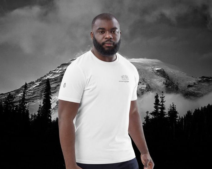 Mann trägt weißes DESTINED T-Shirt mit Brust-Print vor dramatischer Schwarz-Weiß-Bergkulisse