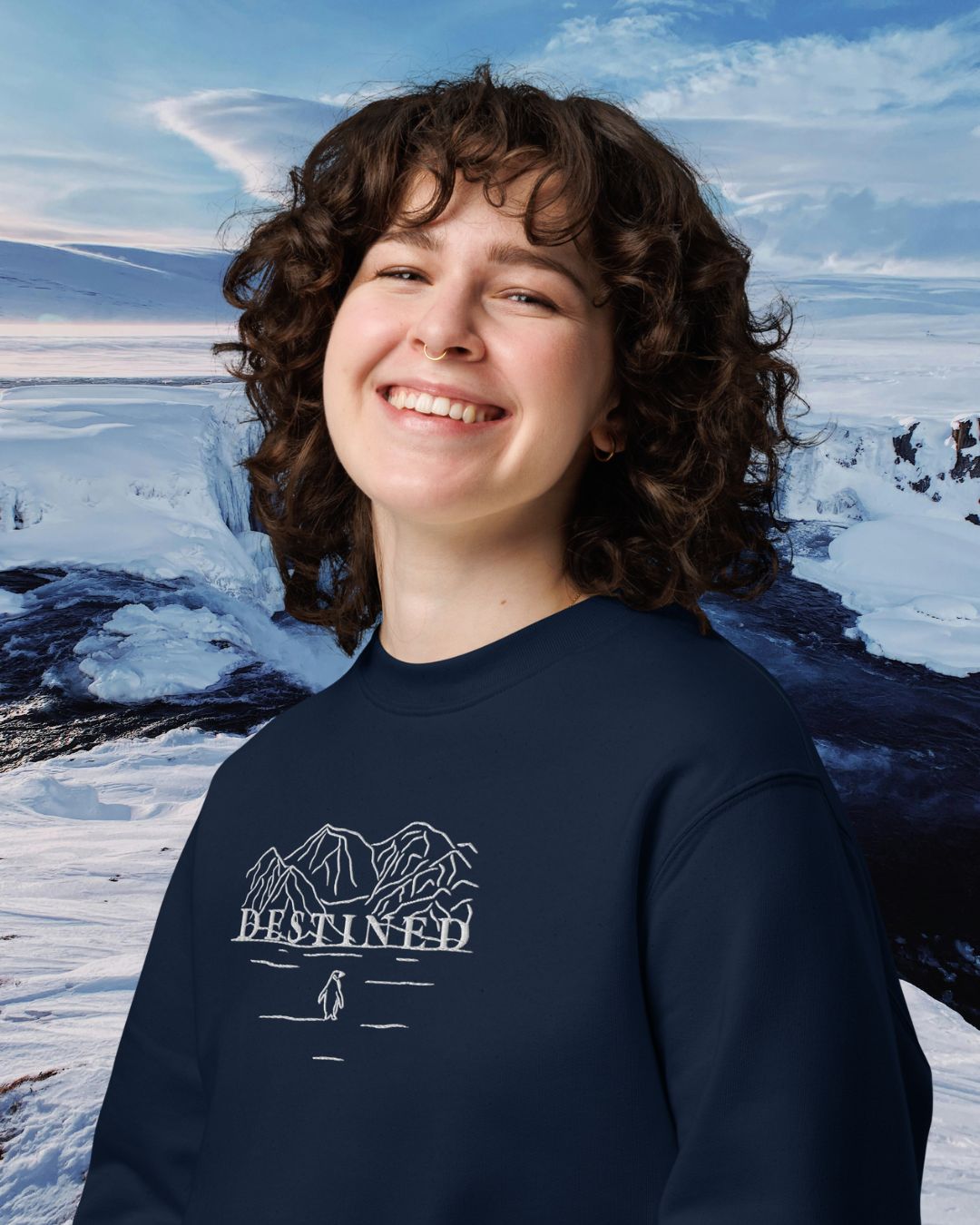 DESTINED Premium Sweatshirt Deep Fjord mit Bergmotiv-Stickerei – Frau trägt Sweatshirt vor arktischer Eislandschaft